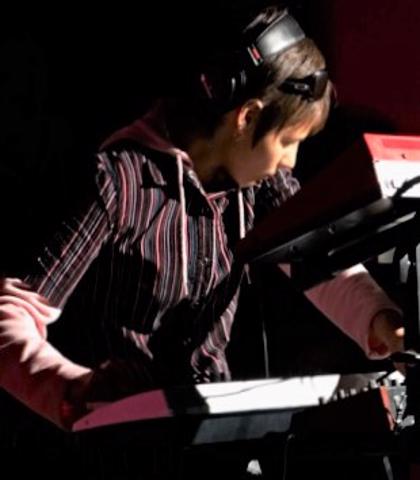 girl playing on synthesizer isolated on black background